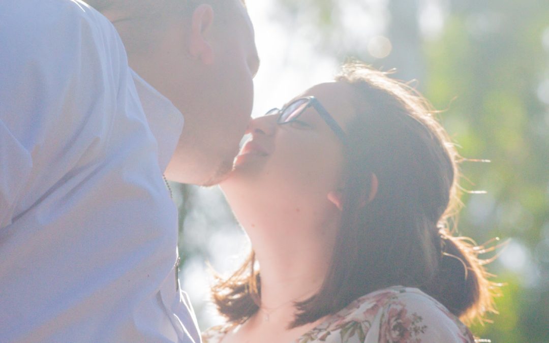 brian and emilee kissing in sunlight portrait