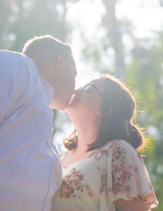 brian and emilee kissing in sunlight portrait